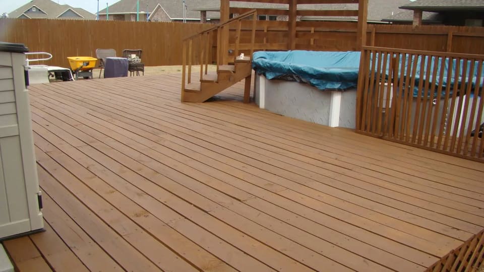 A backyard deck freshly stained a warm sable brown in the OKC metro