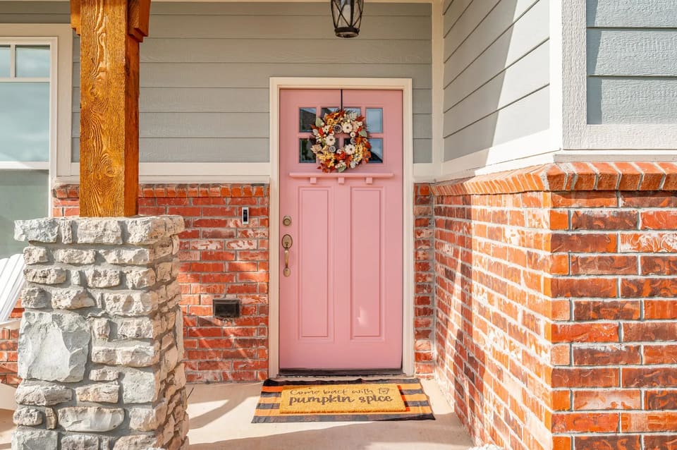Front door painted a warm pink against fresh exterior trim