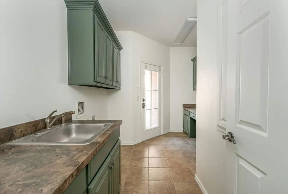 Kitchen and laundry cabinets painted a soft sage green