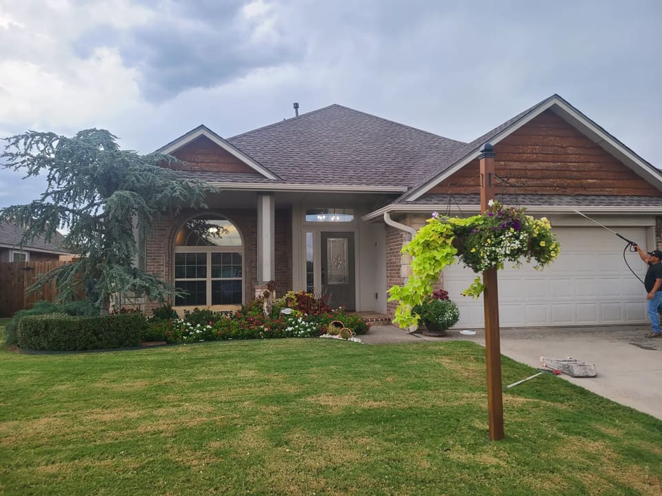 Hometown Painting crew pressure washing an Edmond home's exterior before painting