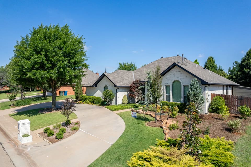 Painted brick Edmond home on Timberdale Drive with a green front door