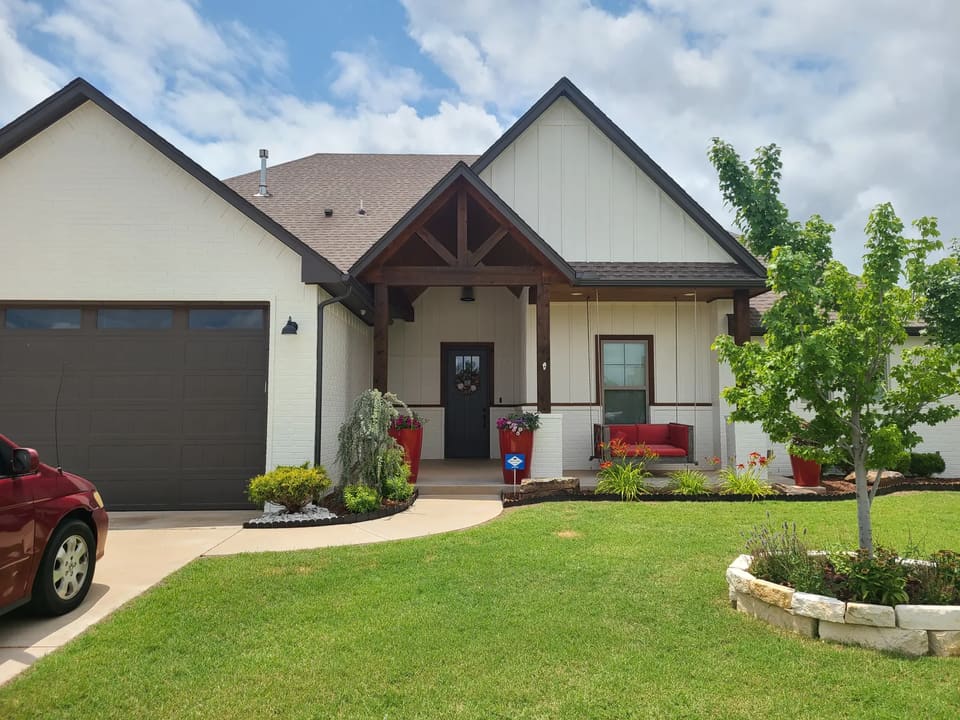 White painted brick home with stained timber porch accents in the OKC metro