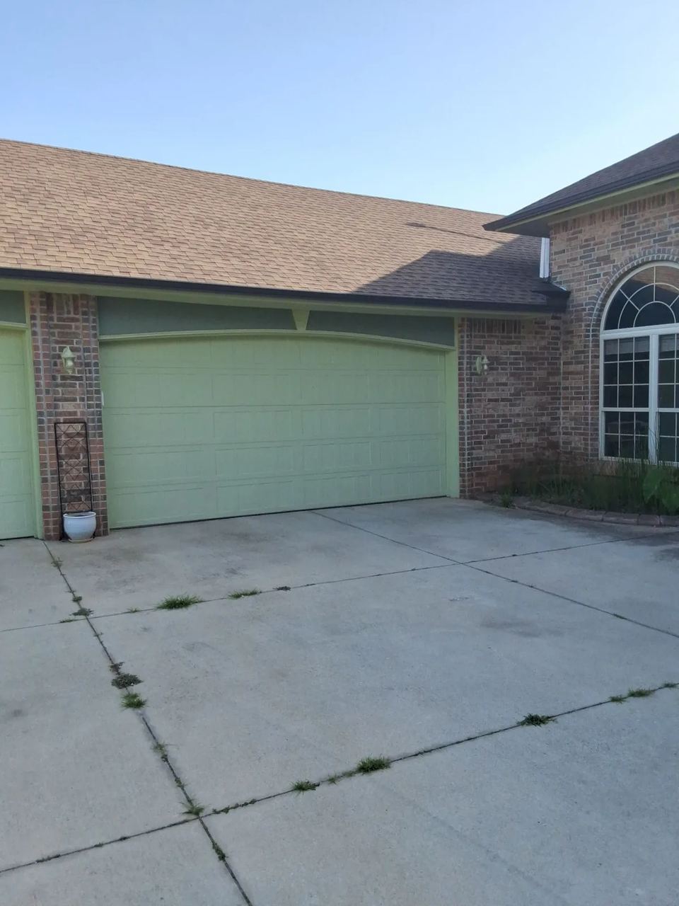 Before: pale green garage doors and green gables on the red brick garage wing