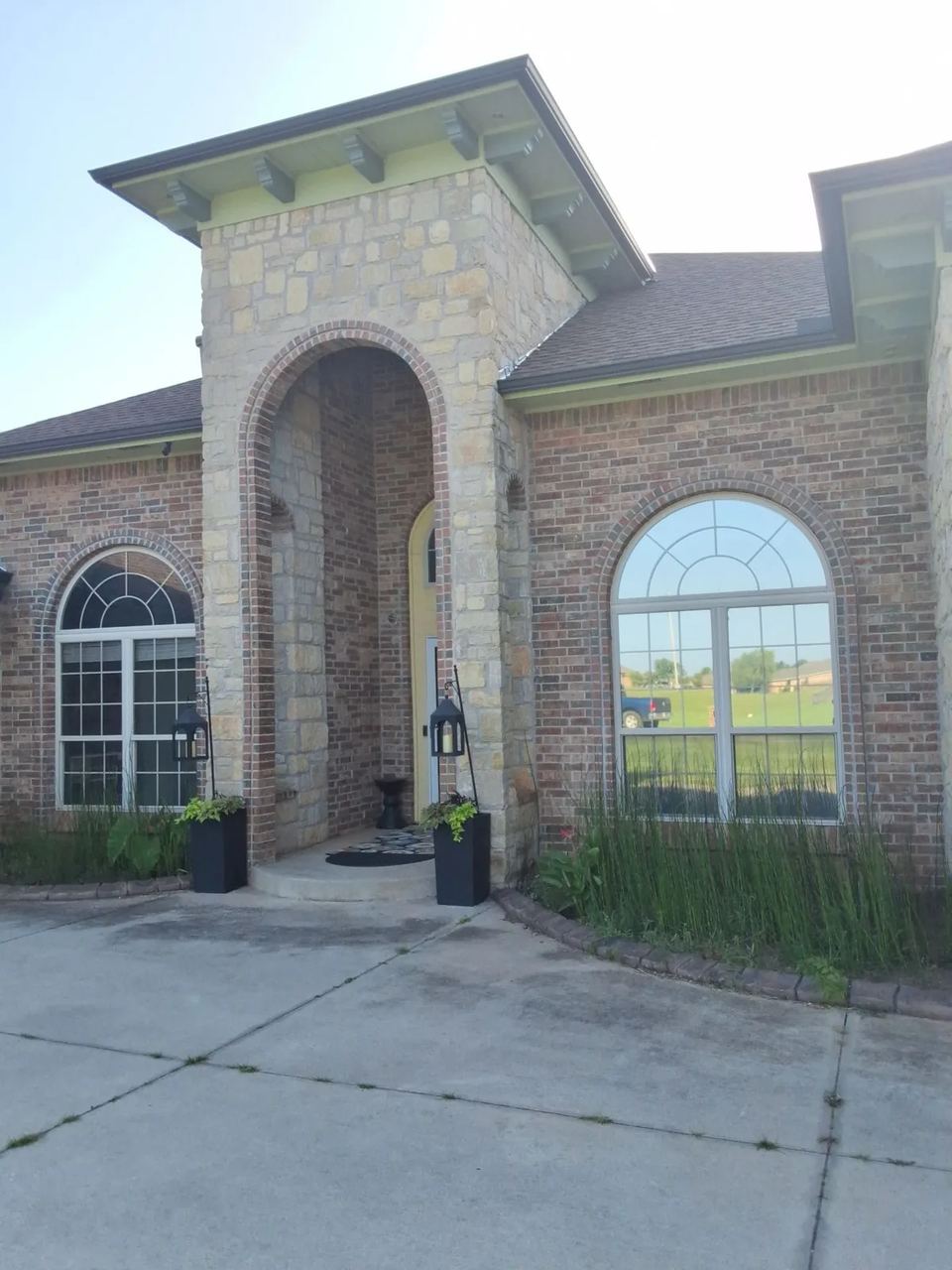 Before: the Edmond home's stone entry arch surrounded by red-orange brick and pale green trim